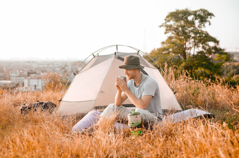 Young man enjoying his food while he camping